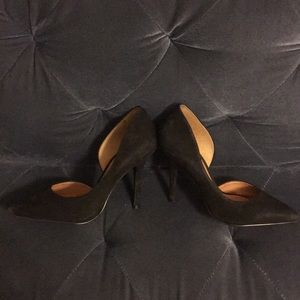 Black suede pumps with arch cutout.